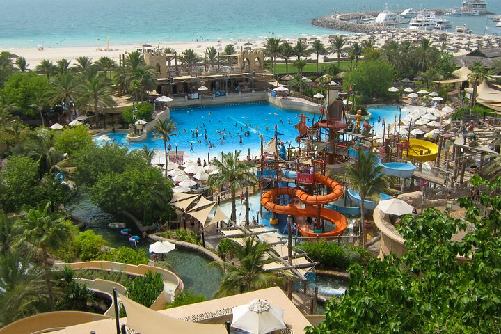 Experience exhilarating water rides relaxing wave pools and inviting lazy rivers at Wild Wadi Waterpark set against the stunning backdrop of Burj Al Arab and sandy beaches.